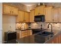 Beautiful kitchen showcasing wooden cabinetry, granite countertops, and modern black appliances at 9718 E Boston St, Mesa, AZ 85207