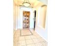 Inviting foyer featuring a decorative tile inlay, a rustic wood door, and an arched alcove niche at 9734 S 182Nd Dr, Goodyear, AZ 85338