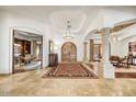 Grand foyer boasts travertine flooring, arched doorways, and decorative lighting at 10798 E Hedgehog Pl, Scottsdale, AZ 85262