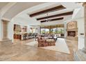 Open concept living room with beamed ceilings, fireplace and travertine floors at 10798 E Hedgehog Pl, Scottsdale, AZ 85262