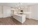 Bright, open kitchen featuring a large island, white cabinets, and modern appliances at 1187 E Ridgerock St, Casa Grande, AZ 85122