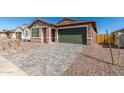 View of a charming single-story home with a paver driveway, desert landscaping and an attached garage at 13242 W Hackamore Dr, Peoria, AZ 85383