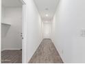 A bright hallway with wood-look flooring and white walls leads to various rooms in the home at 13242 W Hackamore Dr, Peoria, AZ 85383