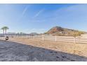 View of the fenced horse property with a backdrop of distant mountains and clear blue skies at 1444 W Gail Rd, San Tan Valley, AZ 85144