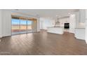 Open-concept living room boasts wood-look tile floors and expansive sliding glass doors for natural light at 14782 W El Cortez Pl, Surprise, AZ 85387