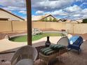 Backyard pool with rock waterfall feature, surrounded by lounge chairs and an enclosed yard at 16132 W Ironwood St, Surprise, AZ 85374