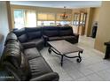 Spacious living room featuring a large sectional sofa, tile flooring, and lots of natural light at 17429 E La Pasada Dr, Fountain Hills, AZ 85268