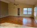 Well-lit living room with hardwood floors, ceiling fan, and neutral paint at 1870 N 128Th Dr, Avondale, AZ 85392