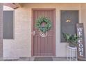 Inviting entryway with a secure screen door, a welcoming wreath, and pleasant potted plants on a tile floor at 2019 E Wahalla Ln, Phoenix, AZ 85024