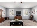 Comfortable living area with neutral carpet, ceiling fan, and bright shuttered windows for abundant natural light at 24027 N 164Th Dr, Surprise, AZ 85387