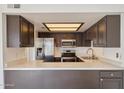 Modern kitchen with stainless steel appliances, quartz countertops and dark cabinetry at 2959 N 68Th Pl # 112, Scottsdale, AZ 85251