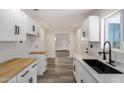 Modern kitchen with white cabinetry, quartz countertops, stainless steel appliances, and plank flooring at 3322 E Willetta St, Phoenix, AZ 85008