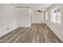 Large living room with plank floors, fresh white paint, and ceiling fan with lighting at 3322 E Willetta St, Phoenix, AZ 85008