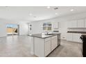 Open kitchen layout with island, stainless dishwasher, granite countertops, and view of the sliding door at 39965 W Venture Rd, Maricopa, AZ 85138