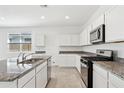 Beautiful kitchen with stainless appliances, granite countertops, island, and white cabinets at 39965 W Venture Rd, Maricopa, AZ 85138