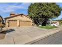 Inviting exterior featuring a spacious driveway, attached garage, and mature landscaping at 474 E Baylor Ln, Gilbert, AZ 85296