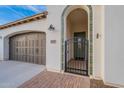 Charming entryway with tiled archway, secured by a wrought iron gate, leads to a welcoming olive-green door at 518 E Laddoos Ave, Queen Creek, AZ 85140