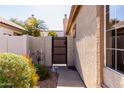 This home features a private side yard with access through a secure wooden gate, framed by lush greenery at 653 S Catalina St, Gilbert, AZ 85233