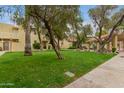 Scenic view of the exterior with well-maintained grounds, trees and BBQ area at 6542 N 7Th Ave # 30, Phoenix, AZ 85013