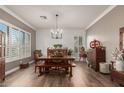 Formal dining room featuring a wood table with bench seating and a modern chandelier at 6881 W Greenbriar Dr, Glendale, AZ 85308