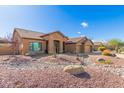 Inviting single-story home with desert landscaping including a stone water feature in the front yard at 6881 W Greenbriar Dr, Glendale, AZ 85308