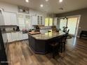 A kitchen featuring modern appliances, wooden floors, granite countertops, and a large island at 6881 W Greenbriar Dr, Glendale, AZ 85308