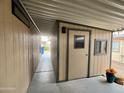 Attached carport leading to a back door, small windows and an open backyard at 9302 E Broadway Rd # 64, Mesa, AZ 85208