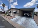 Charming single-story home with an attached carport, landscaped yard and beautiful blue skies at 9302 E Broadway Rd # 64, Mesa, AZ 85208