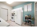 Well-lit kitchen with white appliances, tile flooring, and ample storage at 9550 E Thunderbird Rd # 259, Scottsdale, AZ 85260