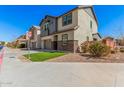 Two story home featuring a gray siding, brickwork, two car garage and desert landscaping at 1075 S Tumbleweed Ln, Chandler, AZ 85286