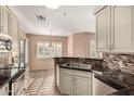 Updated kitchen with granite countertops, mosaic backsplash, and stainless steel appliances at 1295 N Ash St # 125, Gilbert, AZ 85233
