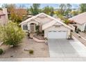 Aerial view of home featuring a spacious driveway, two-car garage, and desert landscaping on a sunny day at 1409 W Maria Ln, Tempe, AZ 85284