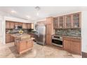 Well-lit kitchen with stainless steel appliances, custom cabinets, granite countertops, and a kitchen island at 1409 W Maria Ln, Tempe, AZ 85284