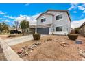 Well-kept gray home with a gravel yard featuring desert landscaping and a two-car garage at 1585 E Jeanne Ln, San Tan Valley, AZ 85140