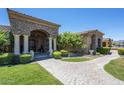 Beautiful desert home showcasing stone accents, manicured landscaping, and a brick walkway leading to the front entrance at 18131 W Palo Verde Ct, Litchfield Park, AZ 85340