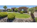 Expansive front yard features lush green grass and well-maintained landscaping that adds curb appeal to the desert home at 18131 W Palo Verde Ct, Litchfield Park, AZ 85340