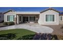 Covered patio area features green turf, neutral paint and sleek pillars at 19139 N 260Th Ave, Buckeye, AZ 85396