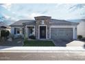 Single story home featuring a stone facade, desert landscaping, and turf yard at 19139 N 260Th Ave, Buckeye, AZ 85396