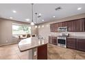 Open kitchen with granite counters, stainless steel appliances and island with pendant lighting at 20934 N Sweet Dreams Dr, Maricopa, AZ 85138