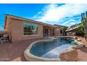 Inviting backyard pool with rock accents, desert landscaping, and covered patio for outdoor entertaining at 20934 N Sweet Dreams Dr, Maricopa, AZ 85138
