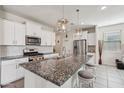 Bright kitchen featuring white cabinetry, granite countertops, a large island, and stainless steel appliances at 22714 N Chase Dr, Maricopa, AZ 85138