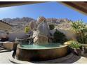 Unique backyard oasis with a rock waterfall feature cascading into a custom-designed pool at 25572 N 113Th Way, Scottsdale, AZ 85255