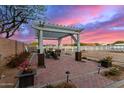 Outdoor patio area with a pergola, brick flooring, and a serene fenced yard, perfect for relaxation at 31301 N Sunflower Way, San Tan Valley, AZ 85143