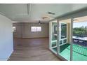 Open living room with natural light, wood floors, and view of the enclosed porch at 349 E Thomas Rd # E301, Phoenix, AZ 85012