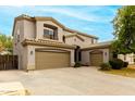 Two-story home features three-car garage, neutral stucco, desert landscaping and clear sky at 3663 S Soho Ln, Chandler, AZ 85286