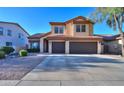 Two-story home with tile roof, desert landscaping, and a spacious driveway leading to a two-car garage at 37262 W Oliveto Ave, Maricopa, AZ 85138