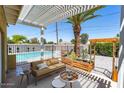 Inviting back patio with pergola, seating area, and view of the refreshing pool and landscaped yard at 3802 E Shaw Butte Dr, Phoenix, AZ 85028