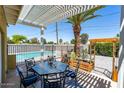 Outdoor living space with pergola, dining set, lush landscaping, and a private pool at 3802 E Shaw Butte Dr, Phoenix, AZ 85028