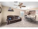 Inviting living area featuring neutral tones, ceiling fan, and open access to the dining area at 45 S 238Th Dr, Buckeye, AZ 85396