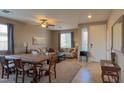 Inviting living and dining area featuring neutral tones, carpet, and a ceiling fan, ideal for relaxation and gatherings at 522 S 122Nd Ln, Avondale, AZ 85323